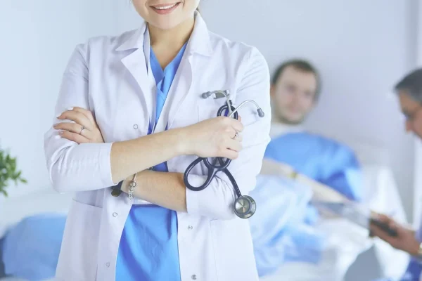 Medico sorridente con stetoscopio e pazienti in ospedale.