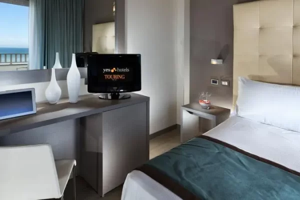 Camera d'albergo moderna con vista mare, scrivania e TV.